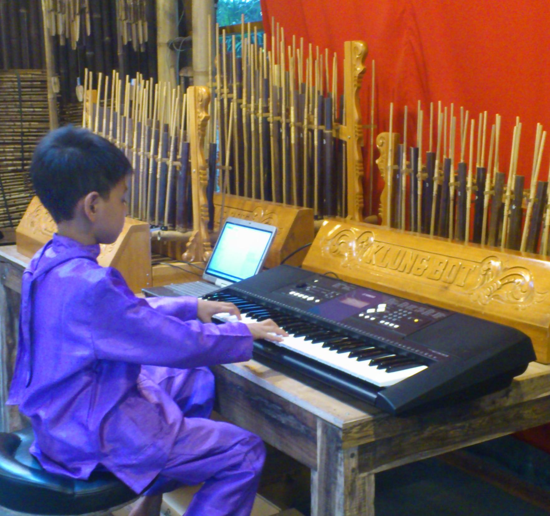 Anak bermain keyboard angklung